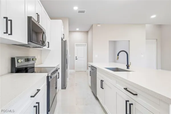 a kitchen with stainless steel appliances granite countertop a sink a stove and a refrigerator