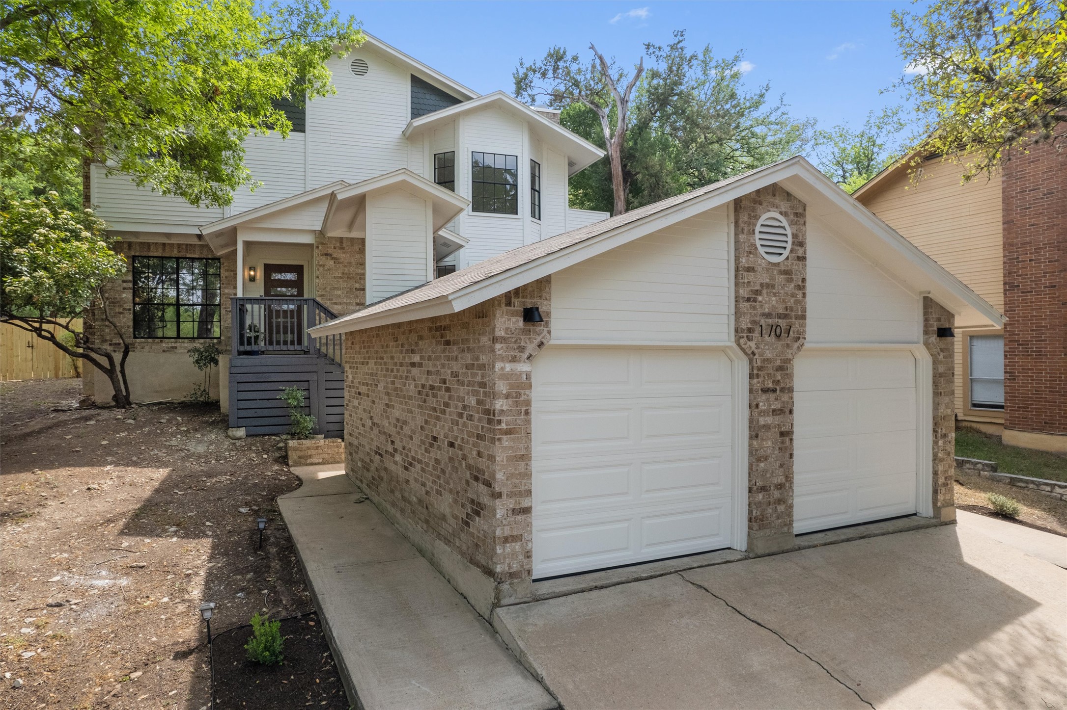 1707 Waterloo Trail Austin, TX 78704 - Photo 1 of 39 Traditional-style home with brick siding, concrete driveway, and an attached garage