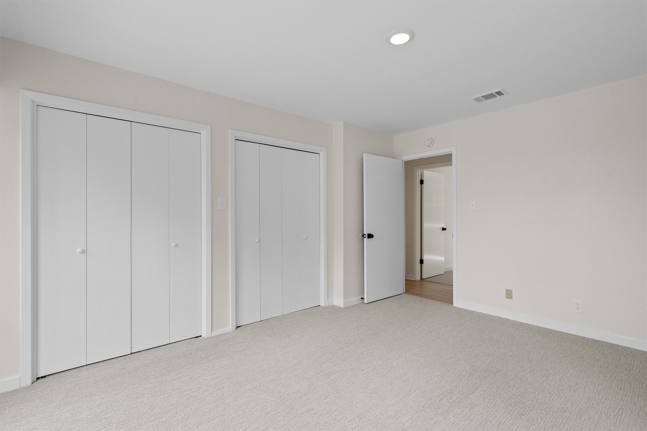 1707 Waterloo Trail Austin, TX 78704 - Photo 20 of 39 Unfurnished bedroom with light colored carpet and multiple closets