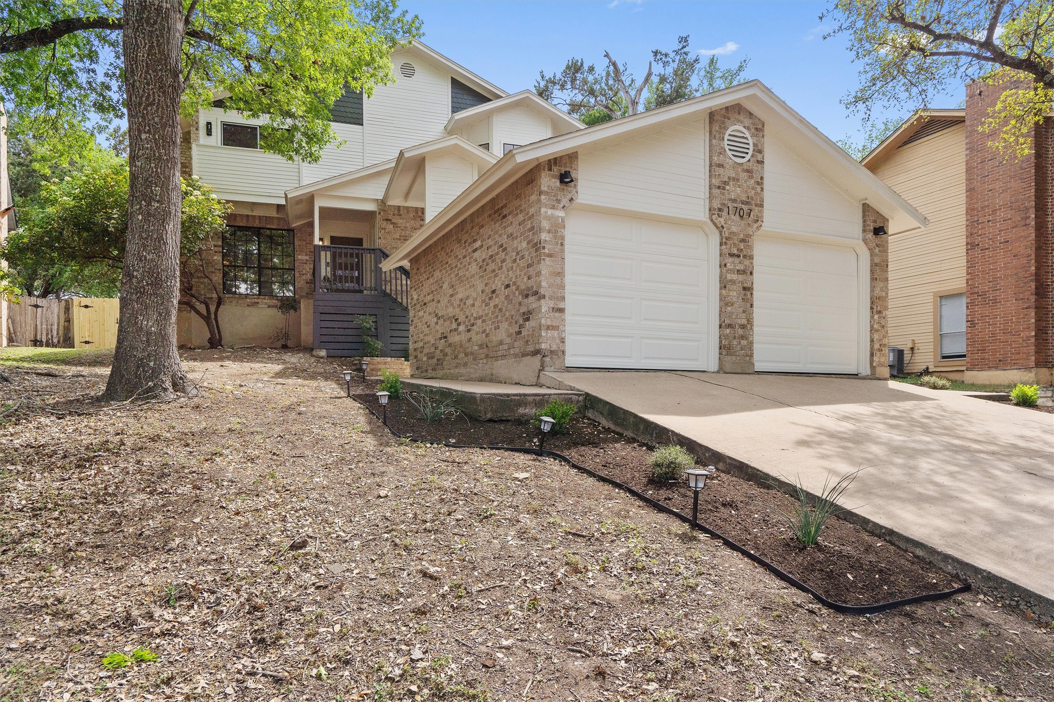 1707 Waterloo Trail Austin, TX 78704 - Photo 2 of 39 View of front facade with driveway, brick siding, a garage, and a porch