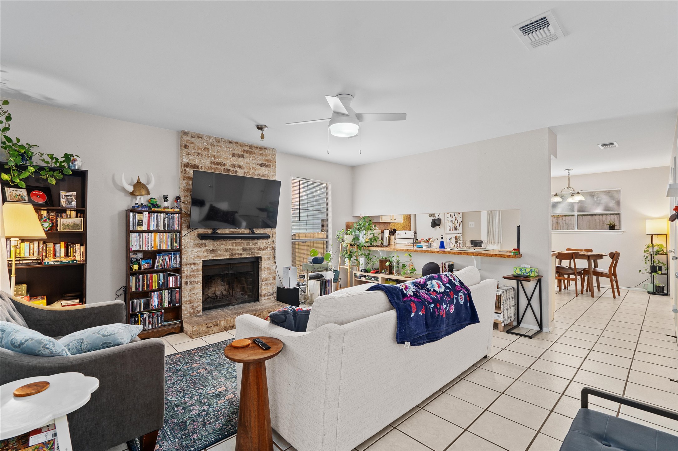 1707 Waterloo Trail Austin, TX 78704 - Photo 29 of 39 Living room featuring ceiling fan, light tile patterned flooring, and a large fireplace