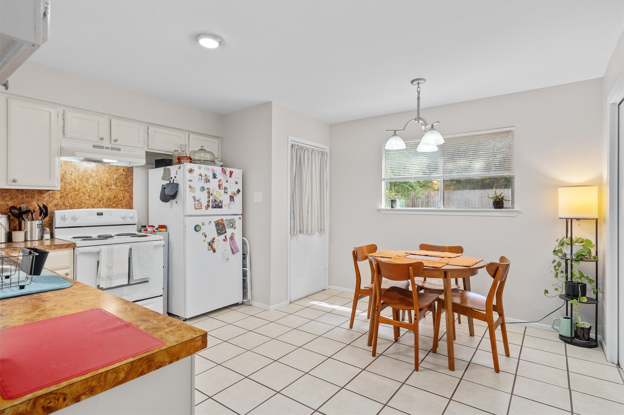 1707 Waterloo Trail Austin, TX 78704 - Photo 30 of 39 Kitchen featuring white appliances, white cabinets, light countertops, decorative light fixtures, and tasteful backsplash