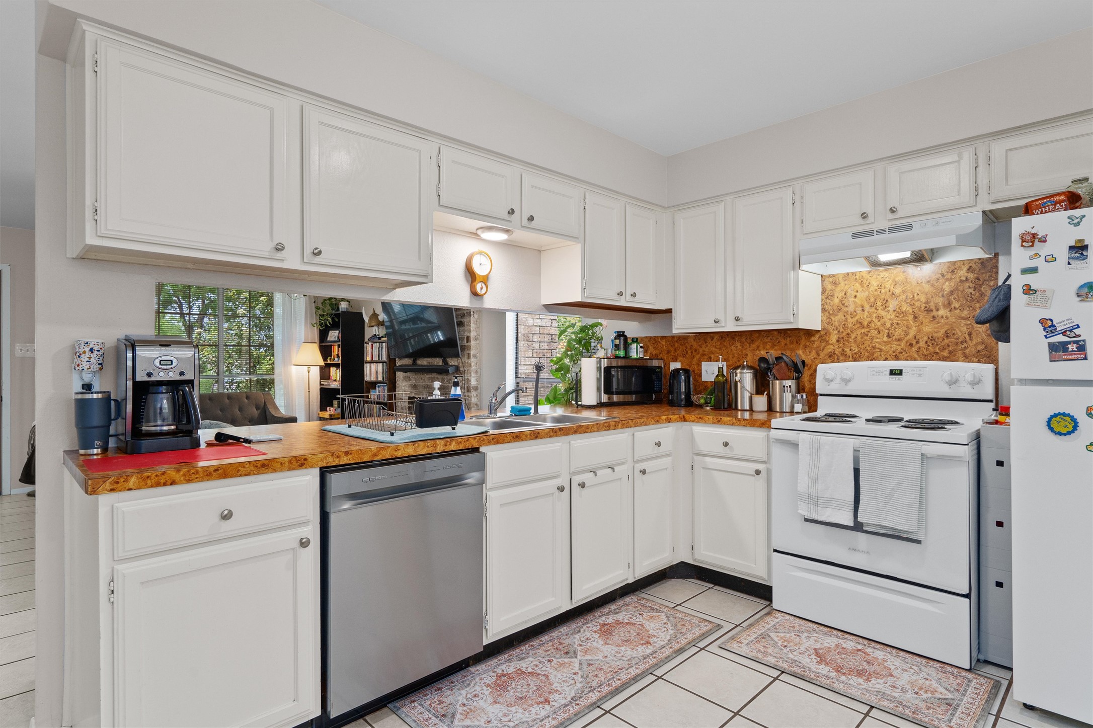 1707 Waterloo Trail Austin, TX 78704 - Photo 31 of 39 Kitchen with stainless steel appliances, white cabinets, light tile patterned flooring, and tasteful backsplash