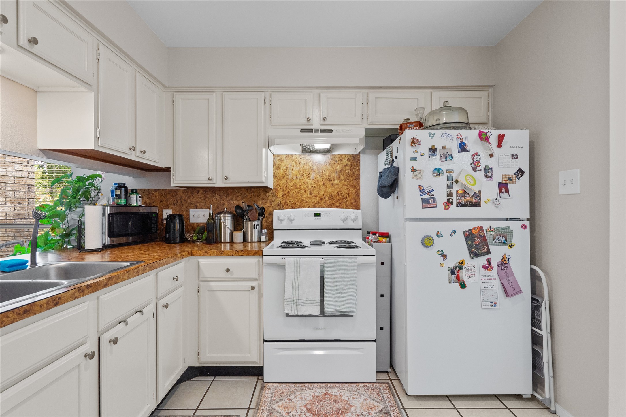 1707 Waterloo Trail Austin, TX 78704 - Photo 32 of 39 Kitchen featuring white appliances, white cabinetry, and light tile patterned floors