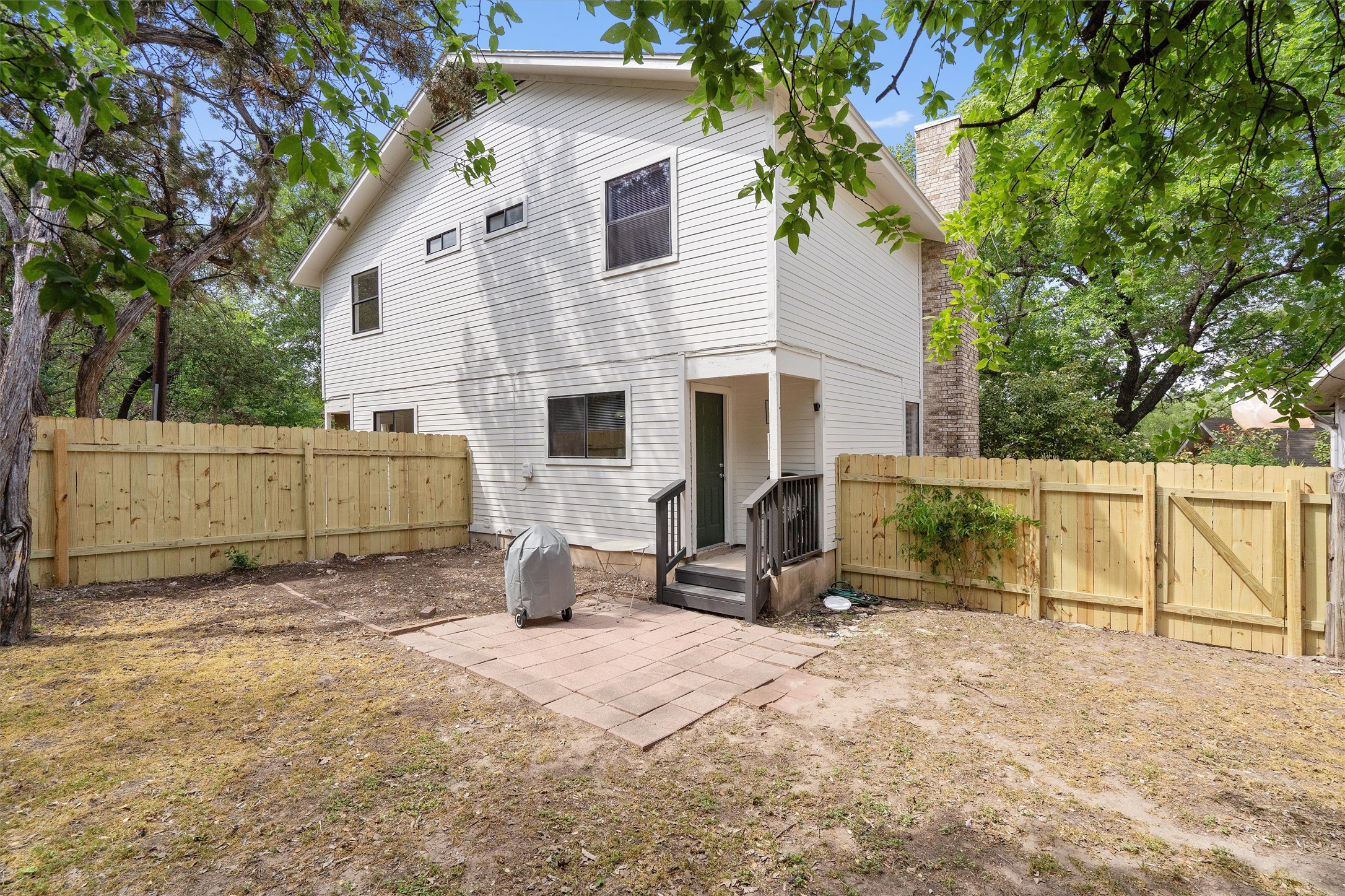 1707 Waterloo Trail Austin, TX 78704 - Photo 36 of 39 Back of house with a patio, a chimney, a fenced backyard, and a gate