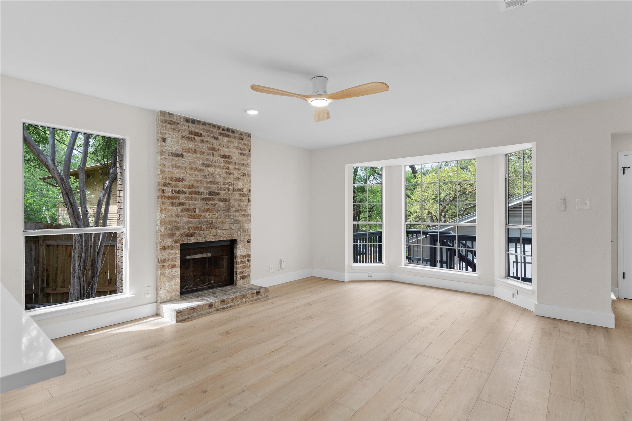 1707 Waterloo Trail Austin, TX 78704 - Photo 8 of 39 Unfurnished living room with ceiling fan, healthy amount of natural light, light wood-style flooring, a brick fireplace, and recessed lighting