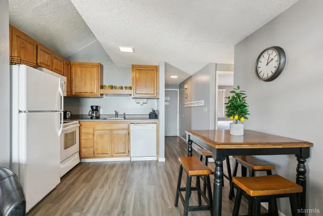 a kitchen with stainless steel appliances granite countertop white cabinets and a stove top oven