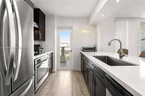 a kitchen with a refrigerator sink and white cabinets