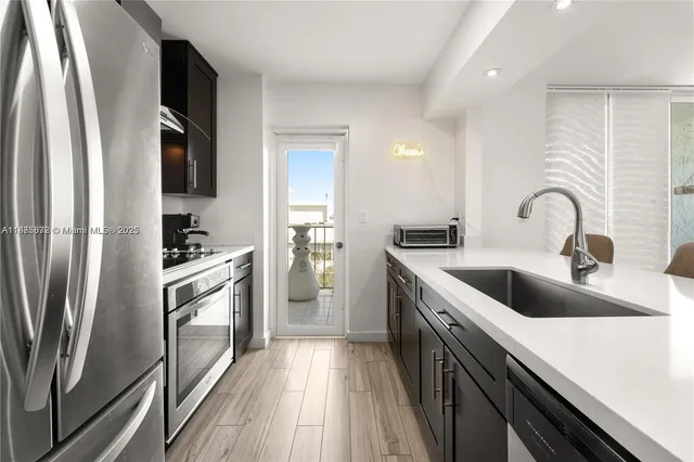 a kitchen with a refrigerator sink and white cabinets