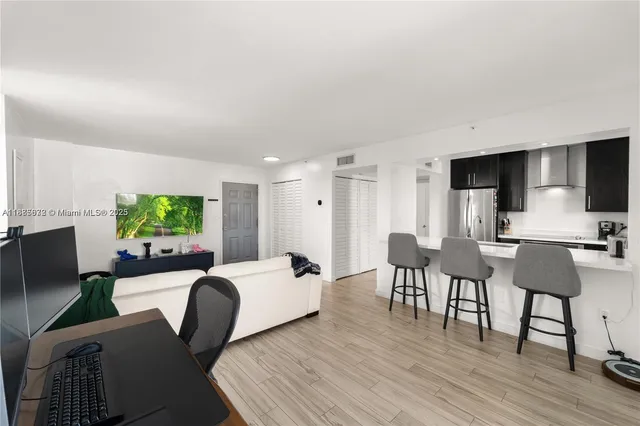 a living room with furniture a window and a flat screen tv