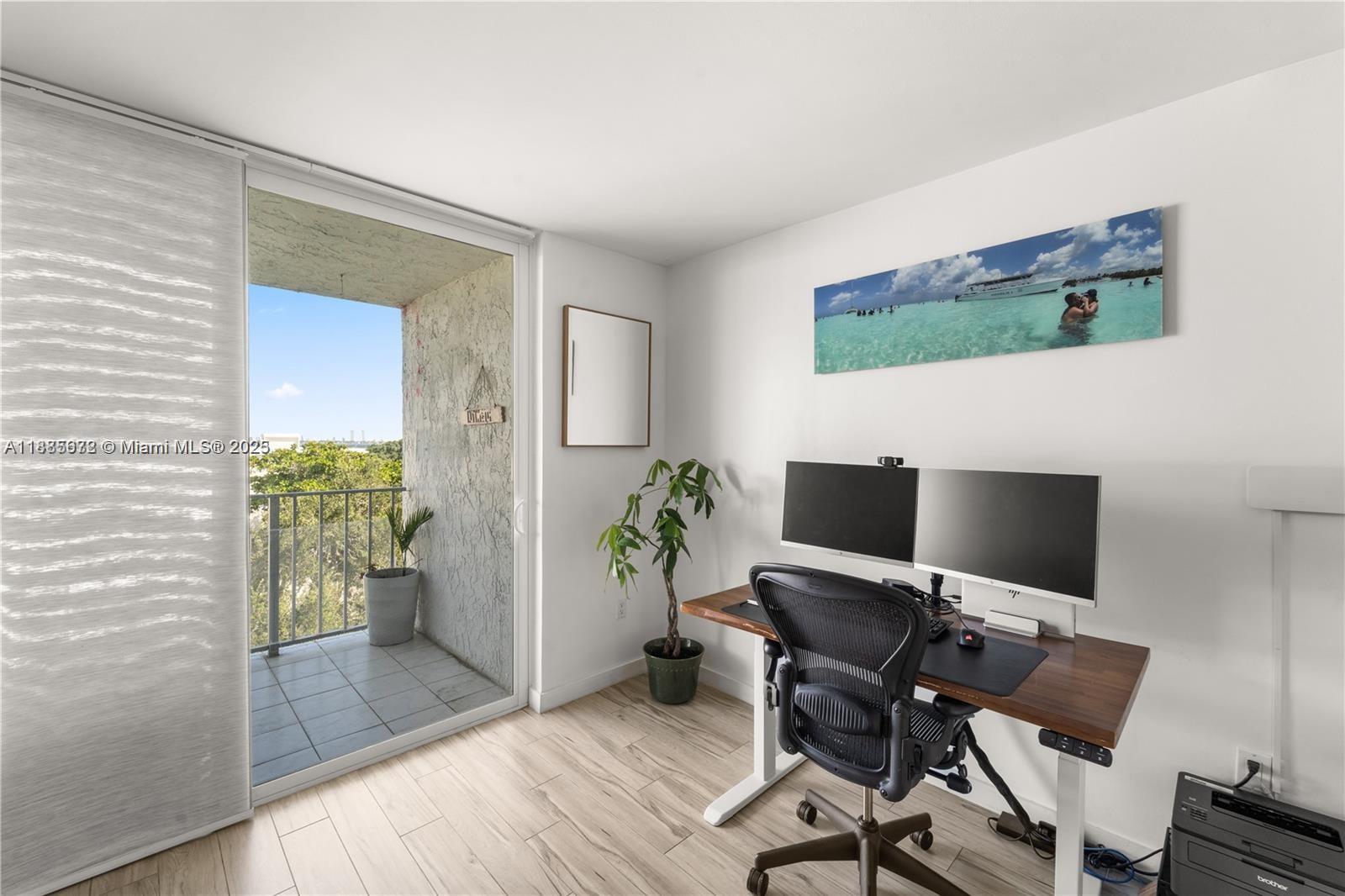 650 Northeast 64th Street, Unit GPH4 Miami, FL 33138 - Photo 6 of 24 a view of a workspace with furniture and wooden floor