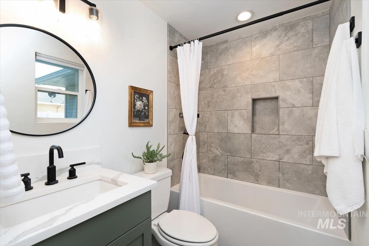 2217 North Middlefield Road Boise, ID 83704 - Photo 27 of 34 Bathroom featuring a white bathtub with a tiled surround, a built-in shower niche, and a dark-finished shower rod