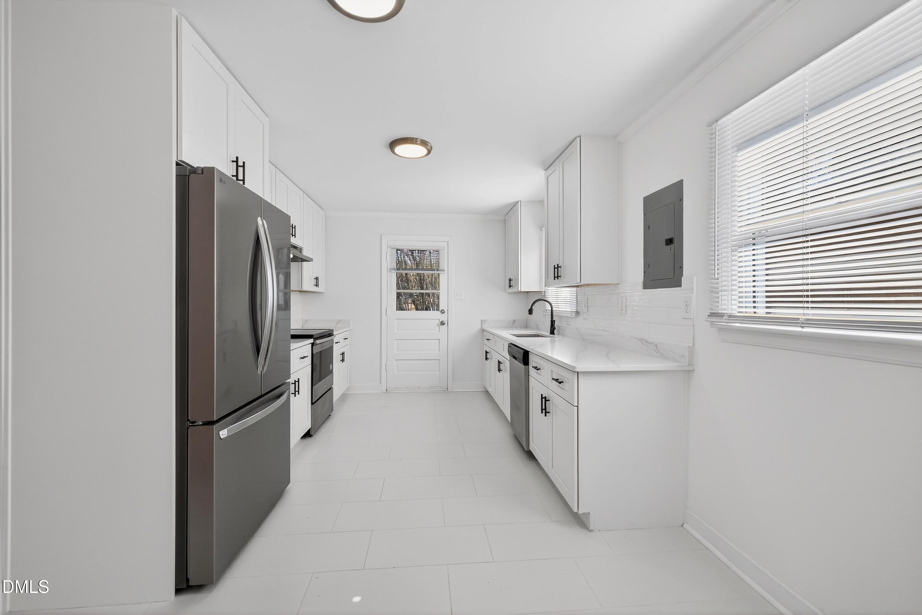 302 Normandy Street Durham, NC 27707 - Photo 8 of 29 a kitchen with white cabinets and stainless steel appliances