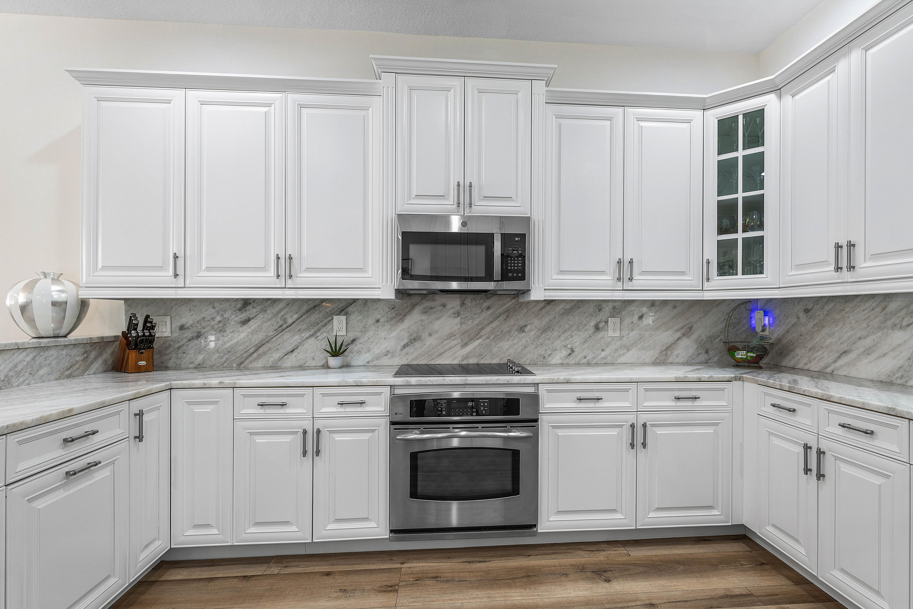 121 Via Poinciana Lane Boca Raton, FL 33487 - Photo 16 of 59 a kitchen with granite countertop white cabinets and stainless steel appliances