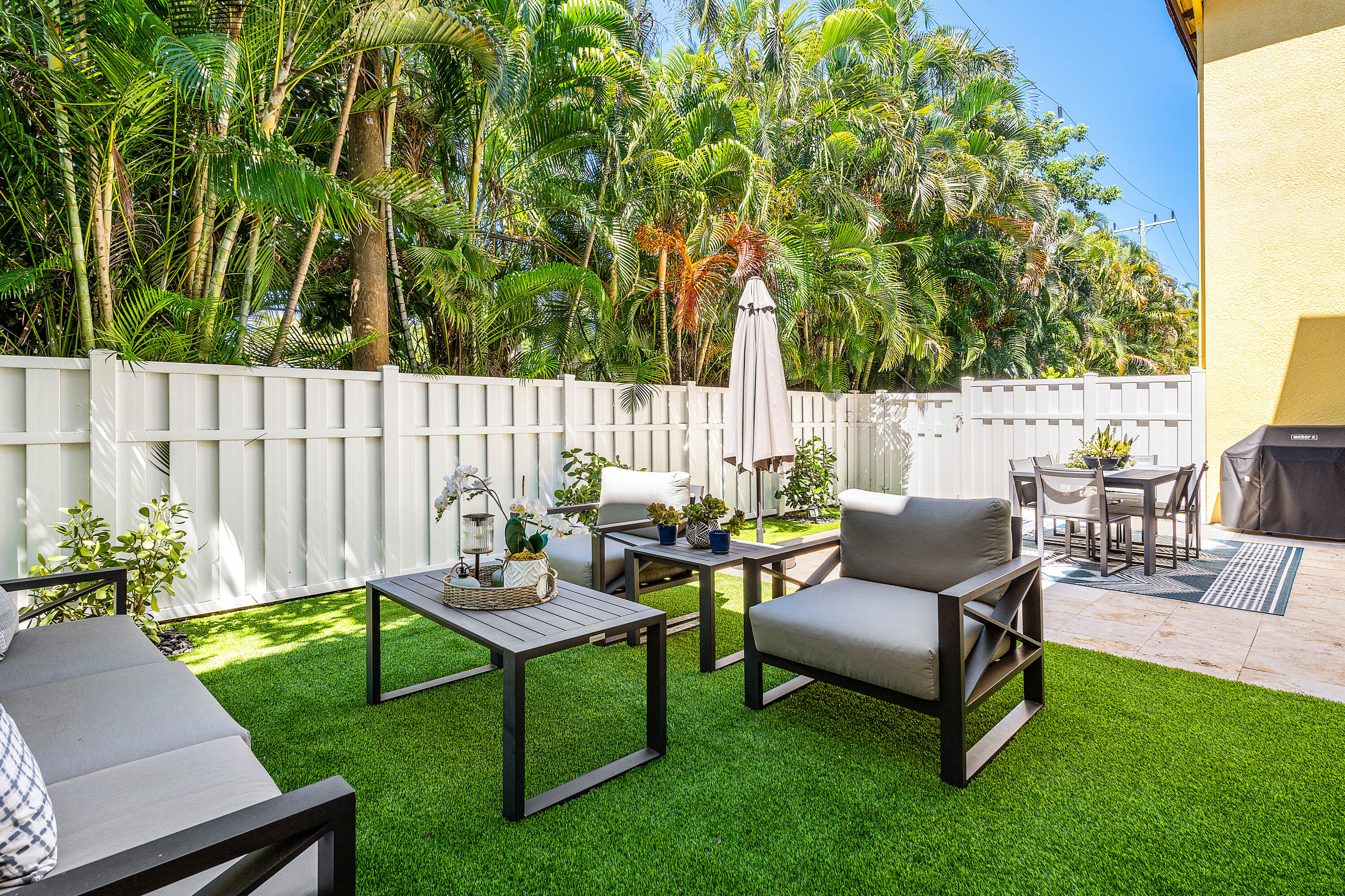 121 Via Poinciana Lane Boca Raton, FL 33487 - Photo 40 of 59 a backyard of a house with table and chairs