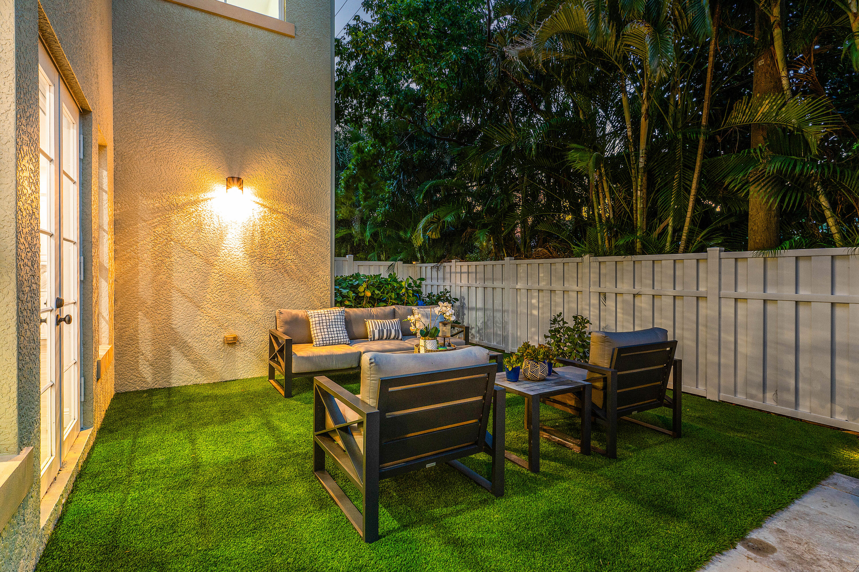 121 Via Poinciana Lane Boca Raton, FL 33487 - Photo 44 of 59 a view of a patio with table and chairs with wooden fence and plants