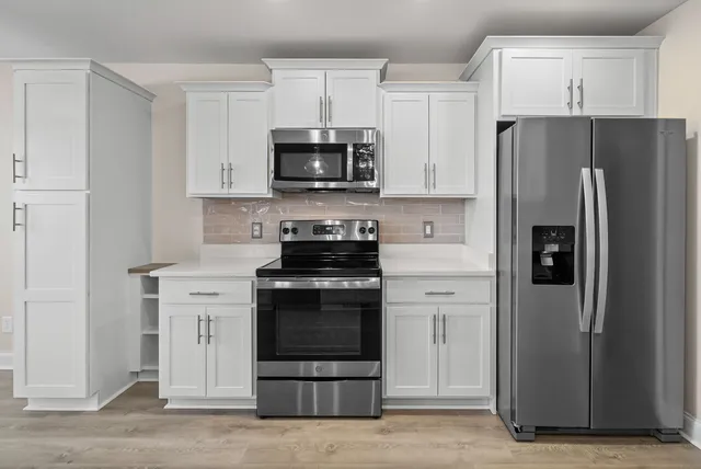 a kitchen with white cabinets and stainless steel appliances