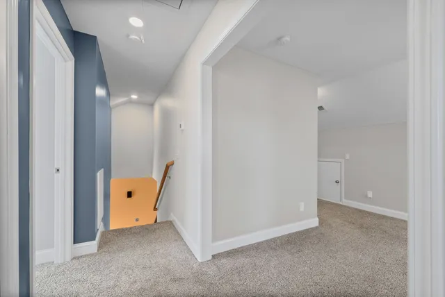 an empty room with wooden floor and mirror