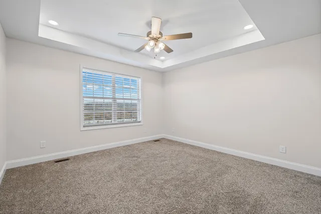 an empty room with fan and windows