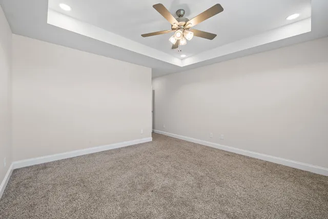 an empty room with a window and a ceiling fan