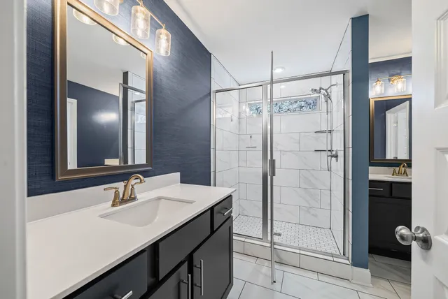 a bathroom with a sink shower and a mirror