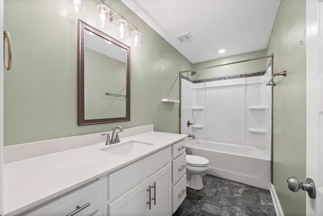 a bathroom with a sink a toilet and a large mirror