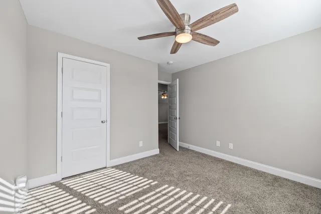 an empty room with closet and fan