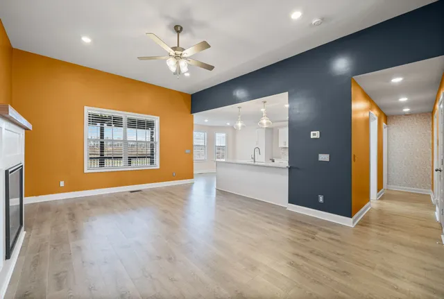 a view of an empty room with window and wooden floor
