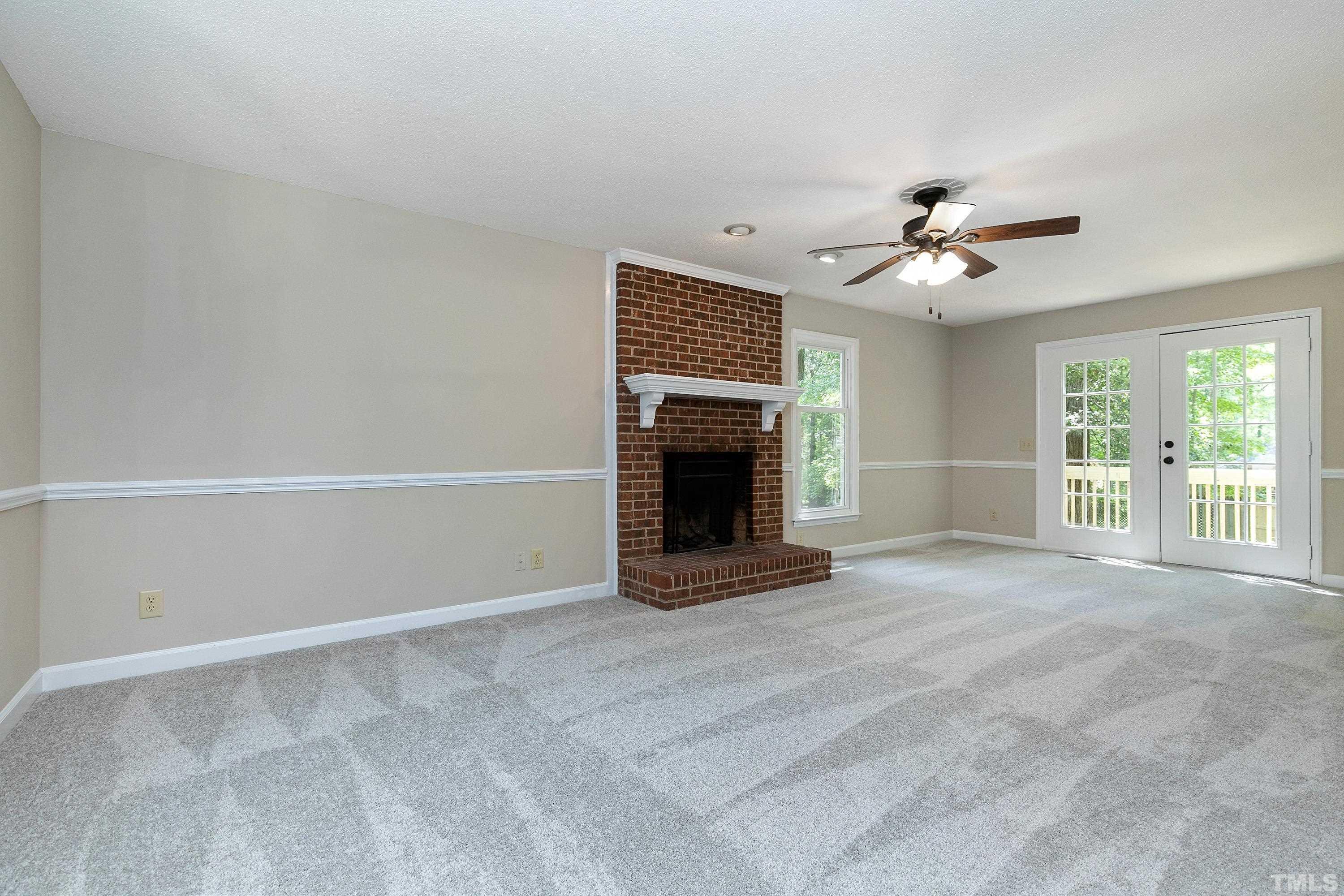 1104 Apache Lane Apex, NC 27502 - Photo 13 of 29 an empty room with windows and fireplace