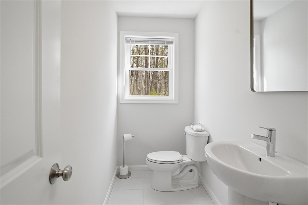 21 Ambrose Way, Unit 21 Shirley, MA 01464 - Photo 12 of 31 a white toilet sitting next to a bathroom sink