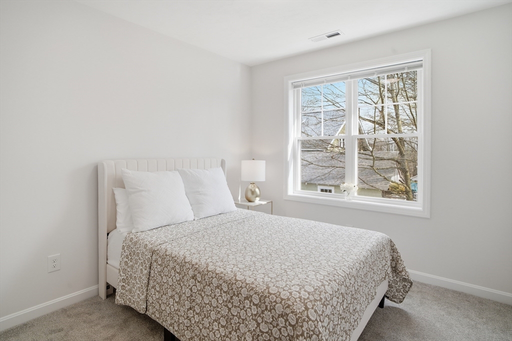 21 Ambrose Way, Unit 21 Shirley, MA 01464 - Photo 14 of 31 a large bed sitting in a bedroom next to a window