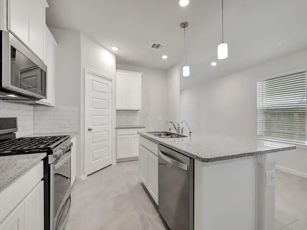 a kitchen with stainless steel appliances granite countertop a sink and a stove