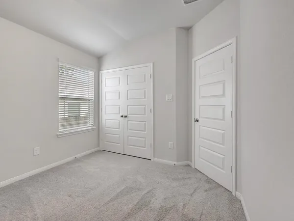 an empty room with windows and closet