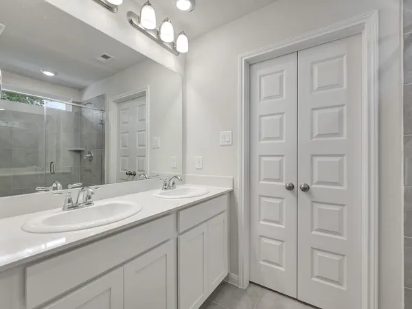 a bathroom with a double vanity sink a mirror and a shower