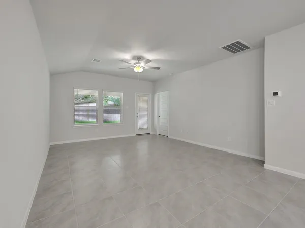 an empty room with windows and fan