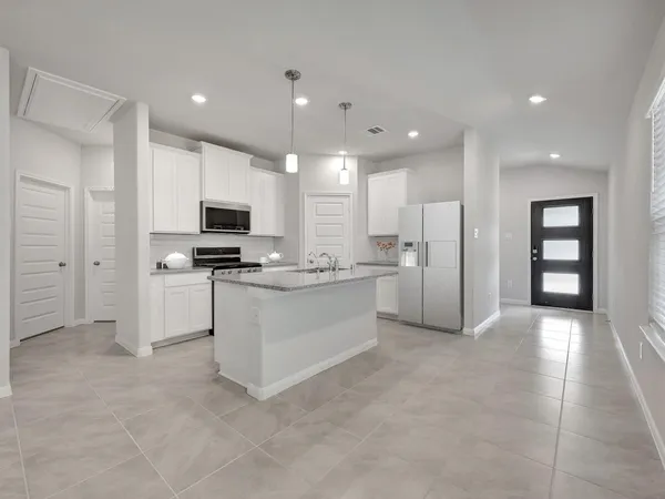 a kitchen with white cabinets and appliances