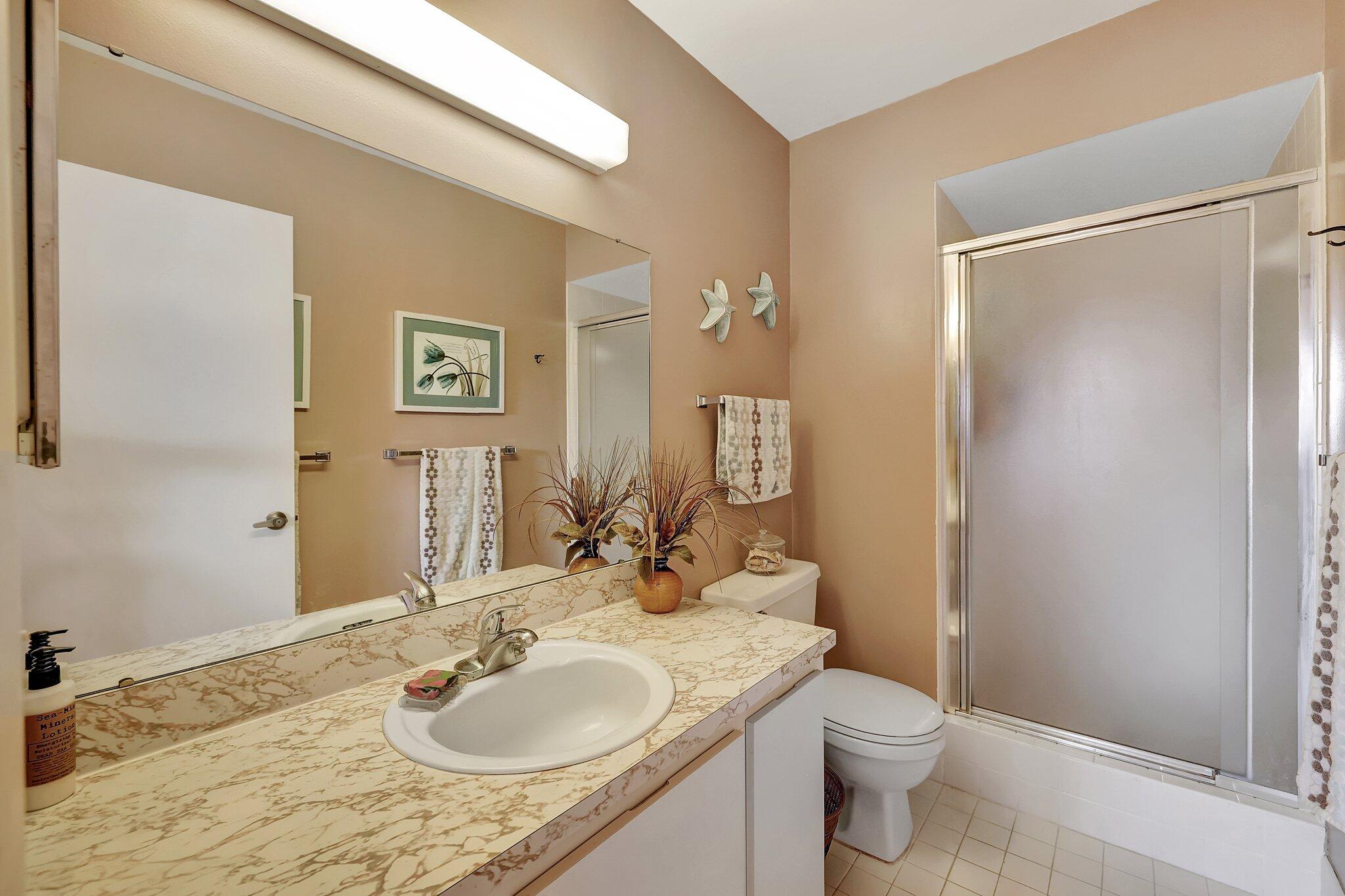 3001 Southeast Aster Lane, Unit 906 Stuart, FL 34994 - Photo 18 of 24 a bathroom with a granite countertop sink toilet and shower