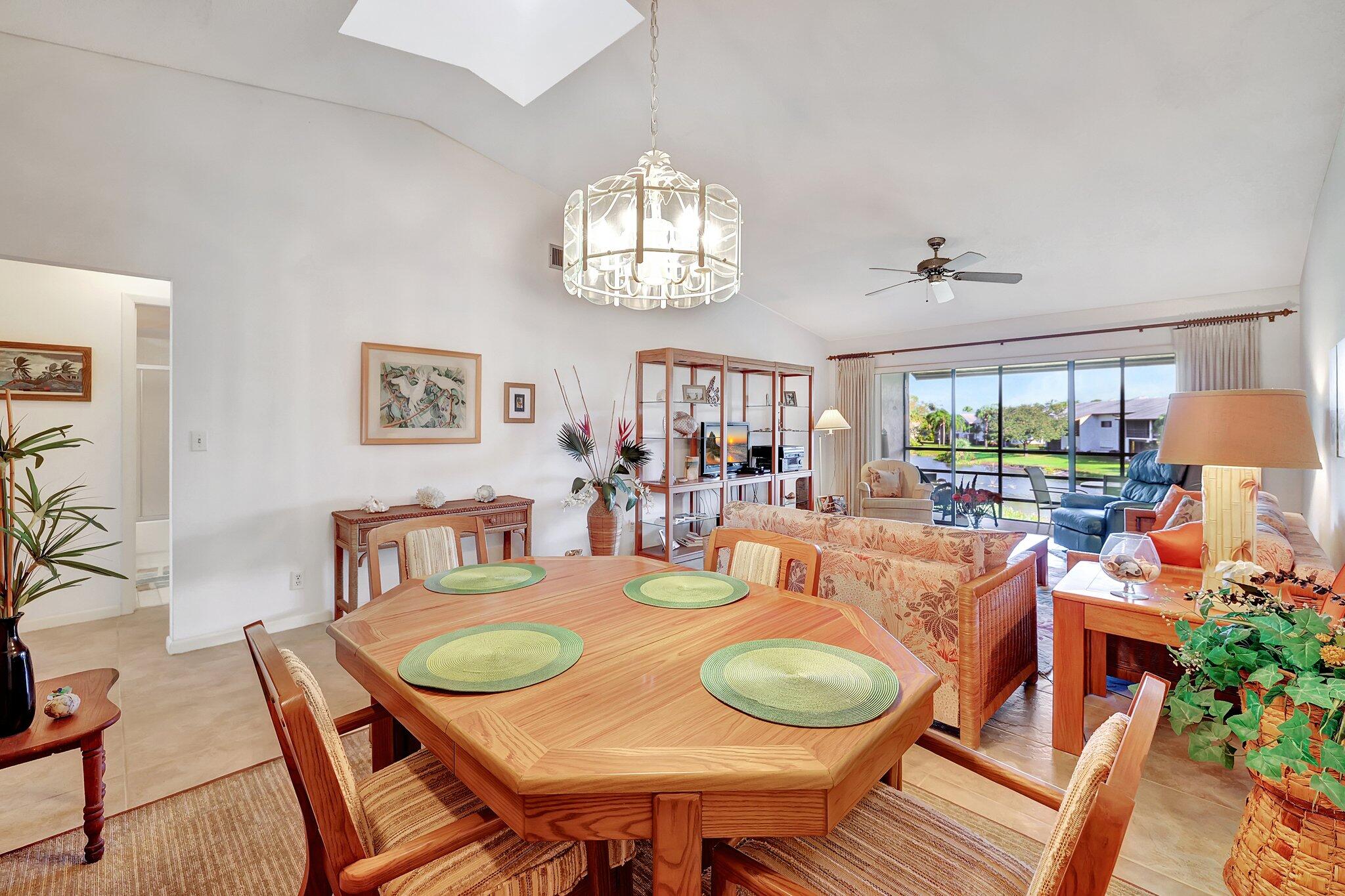 3001 Southeast Aster Lane, Unit 906 Stuart, FL 34994 - Photo 6 of 24 a dining room with furniture a window and wooden floor