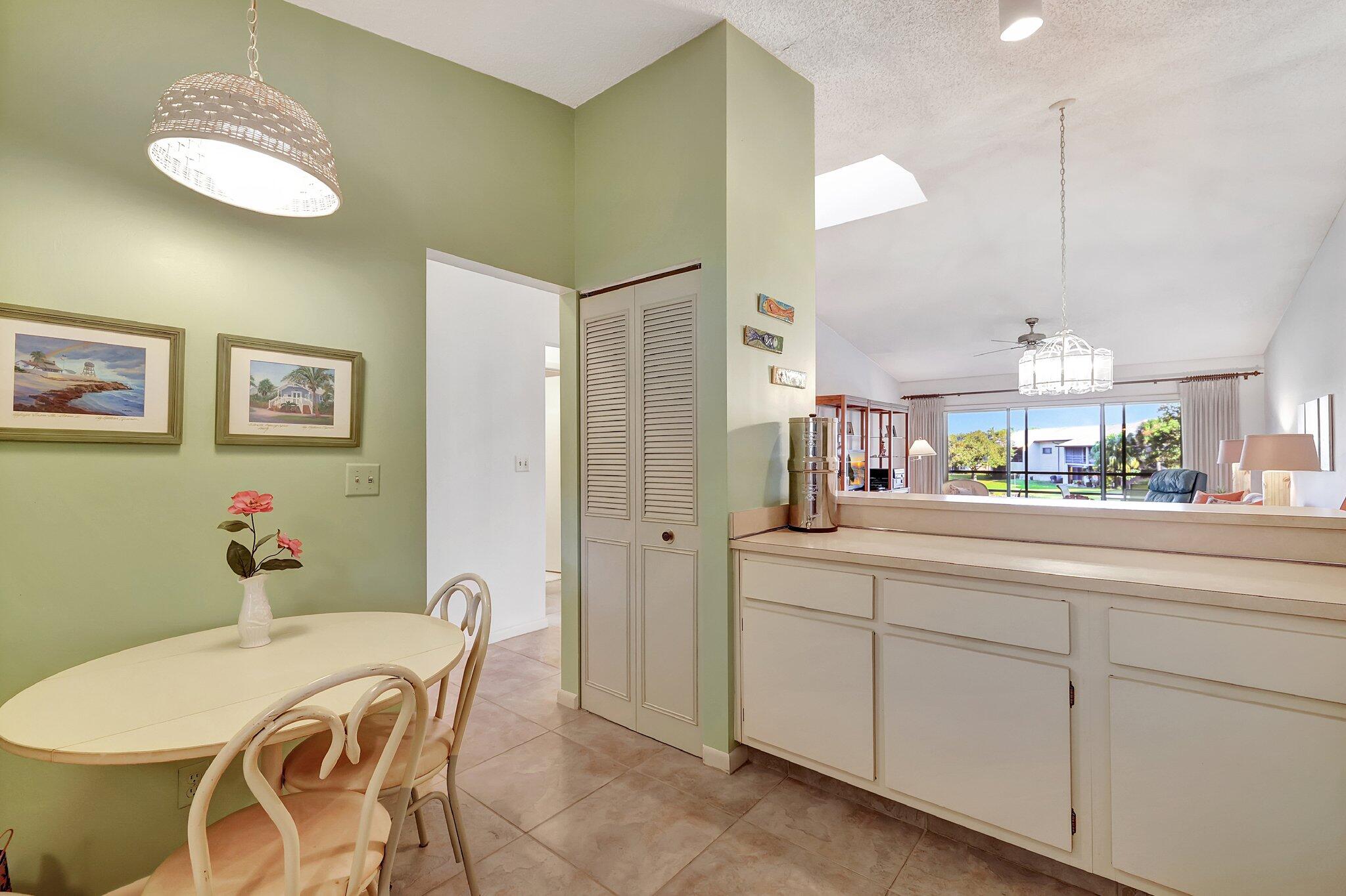 3001 Southeast Aster Lane, Unit 906 Stuart, FL 34994 - Photo 8 of 24 a room with a table chairs and a kitchen view