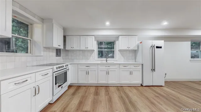 a kitchen with white cabinets and appliances