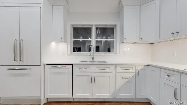 a kitchen with white cabinets and a sink