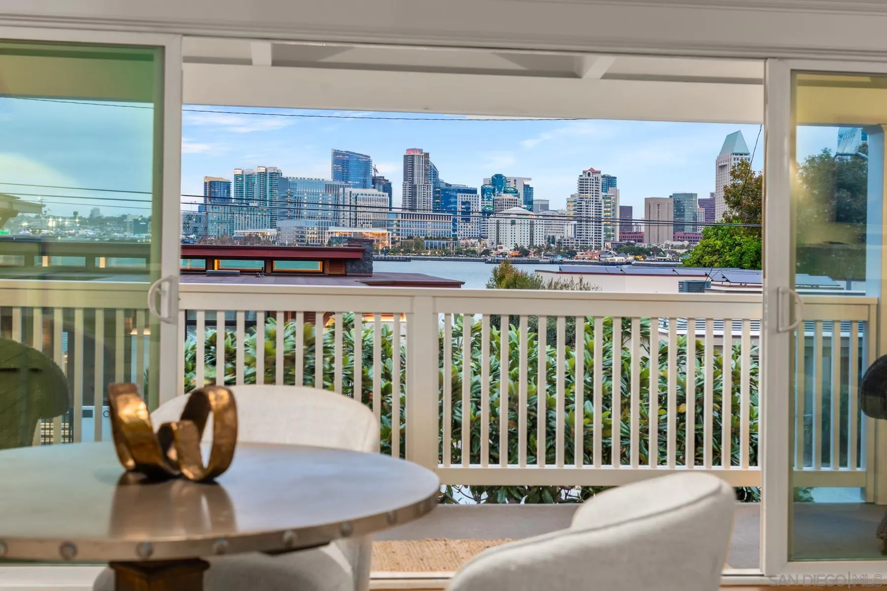 a view of a city from a balcony with chairs