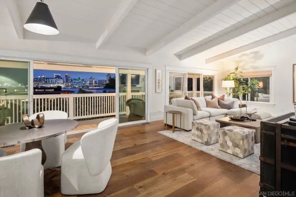 a living room with furniture large window and wooden floor