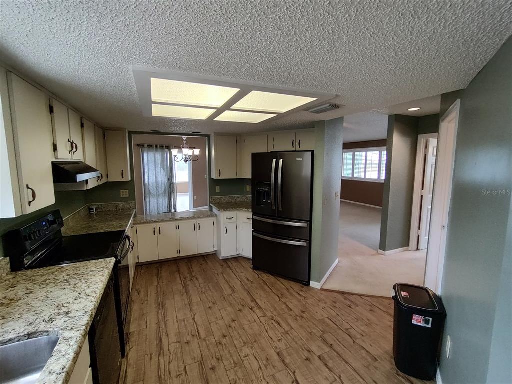 8792 Southwest 116th Place Road Ocala, FL 34481 - Photo 12 of 36 a kitchen with stainless steel appliances kitchen island granite countertop a refrigerator a sink a stove and oven