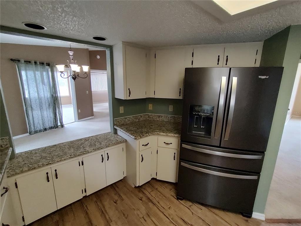 8792 Southwest 116th Place Road Ocala, FL 34481 - Photo 14 of 36 a kitchen with granite countertop stainless steel appliances and wooden cabinets