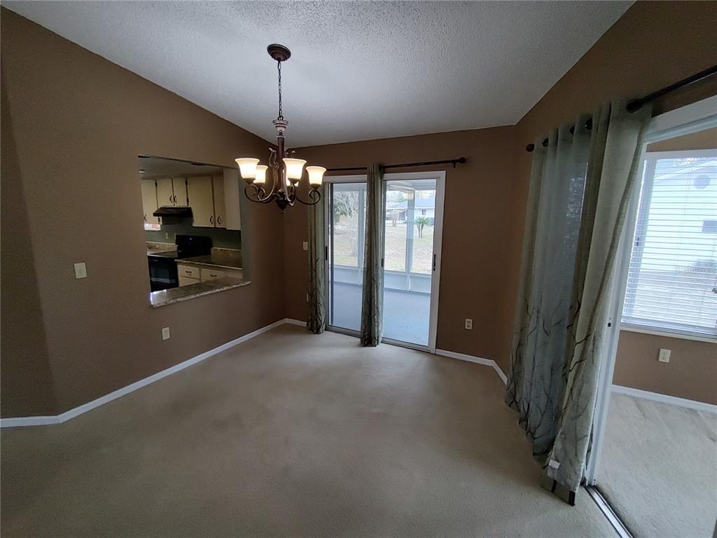 8792 Southwest 116th Place Road Ocala, FL 34481 - Photo 9 of 36 a view of a room with a chandelier fan and windows