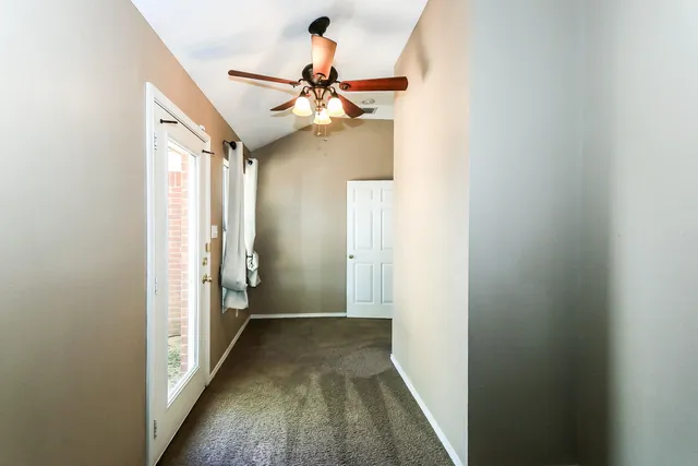 a view of a hallway with a chandelier fan and wooden floor