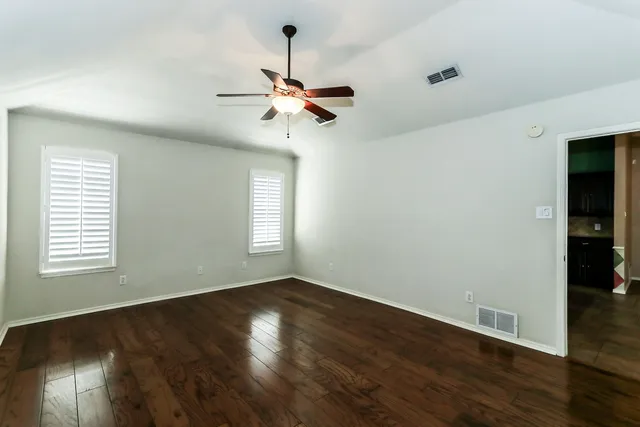 a view of a room with wooden floor and windows