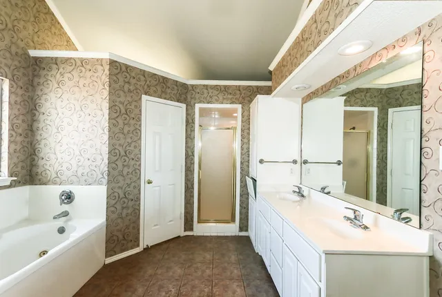 a spacious bathroom with a bathtub sink and mirror