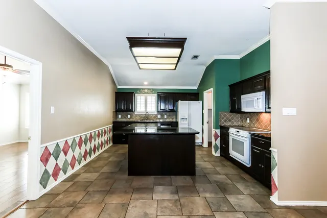 a large kitchen with stainless steel appliances granite countertop a stove top oven a sink and dishwasher